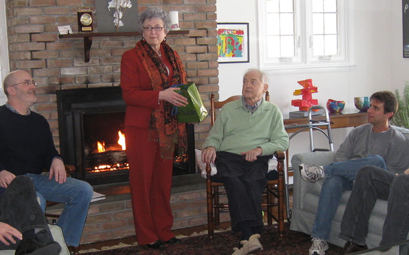 group of people sitting by fireplace