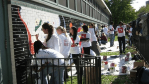 students painting brick wall