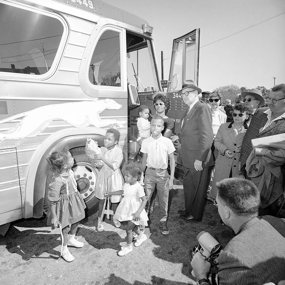 black and white photo of family getting off bus