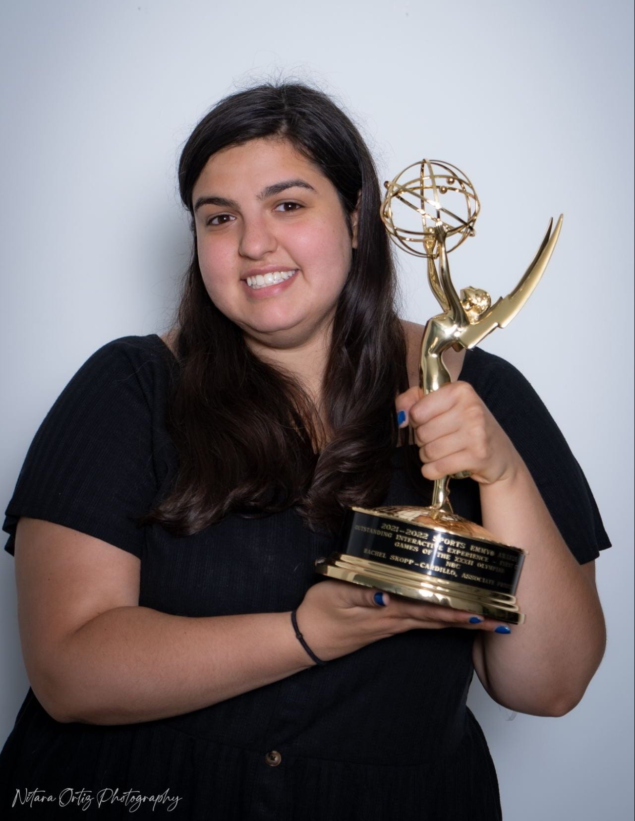a woman and a young girl holding an Emmy